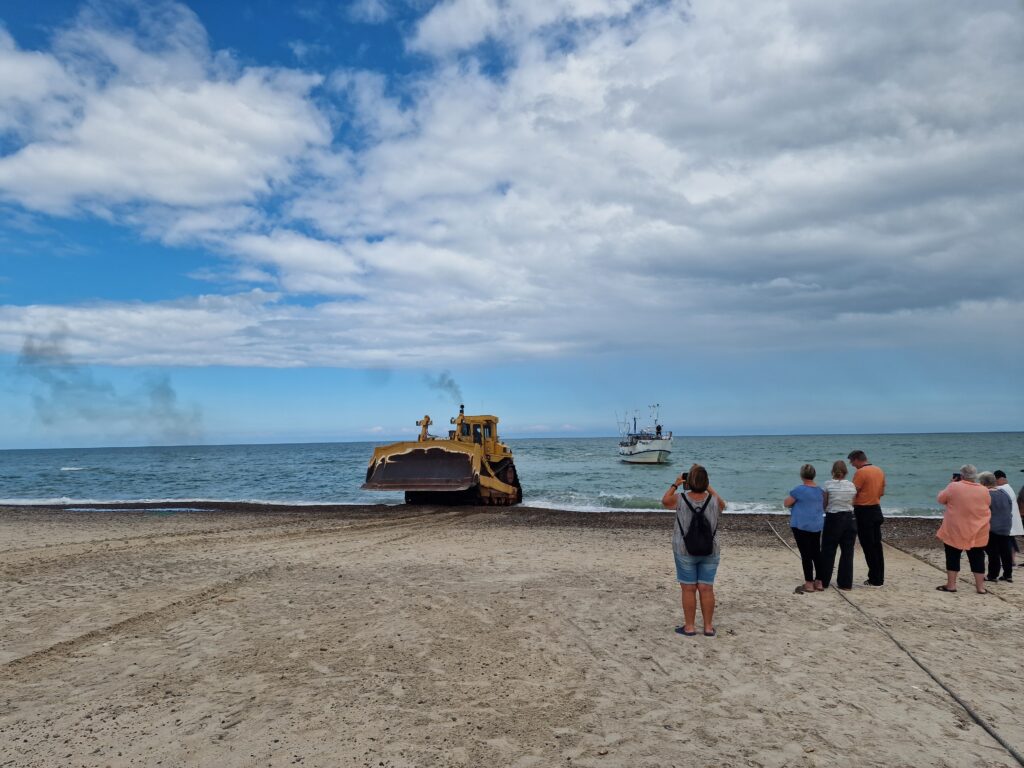 Fiskekutter bliver trukket op på stranden